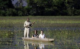 Botswana safari - couple in a mokoro with safari guide