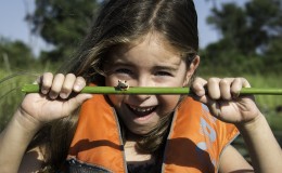 Botswana family safari - girl canoeing in the Delta on safari with a frog 