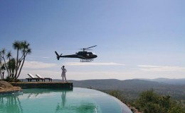 Heli safari at Loisaba, Kenya - lady by infinity pool with helicopter