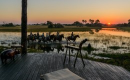 Group of horse riders through the Okavango Delta at sunset Botswana African Horseback Safaris