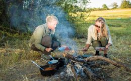 Miracle cooking on safari -ladies cooking around a camp fire in the bush