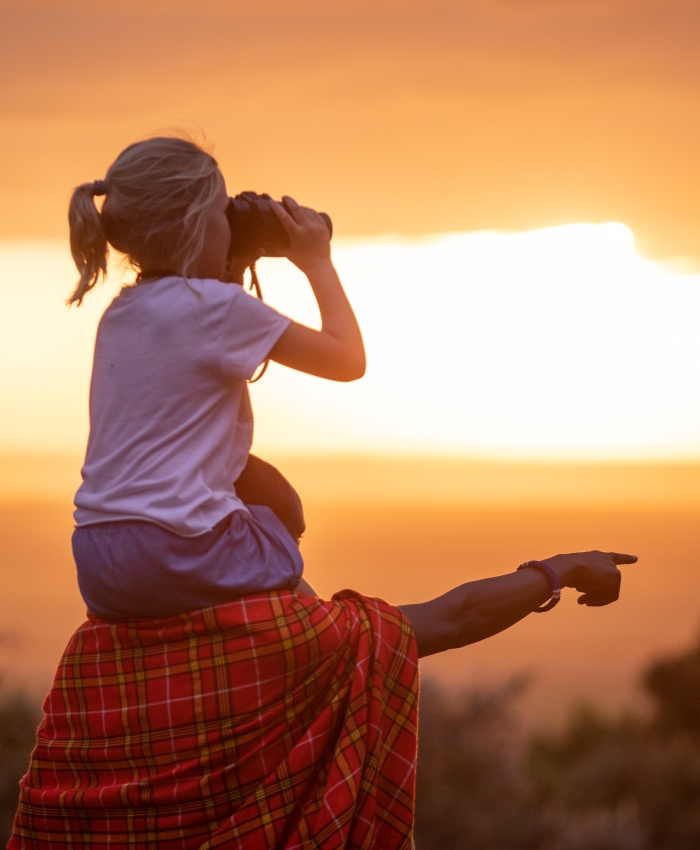 Mother and child watching the sunset on safari in Africa on a family safari
